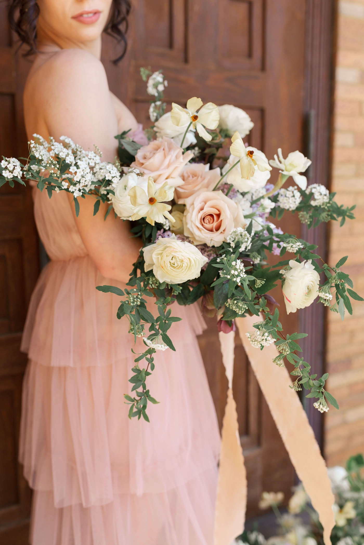 Bridal bouquet filled with yellow cosmos, pink roses, and Sweet alyssum by Wild Indigo